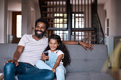 Buy stock photo Shot of an adorable little girl watching tv and spending time with her father at home