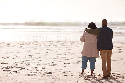 Buy stock photo Rearview shot of a happy mature couple watching the sunset at the beach