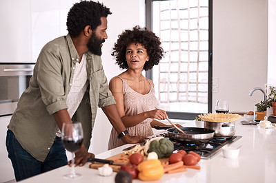 Buy stock photo Shot of a man talking to his wife while she cooks