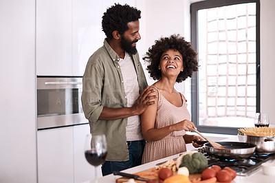 Buy stock photo Shot of a man embracing his wife while she cooks