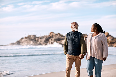 Buy stock photo Shot of a happy mature couple going for a romantic walk along the beach