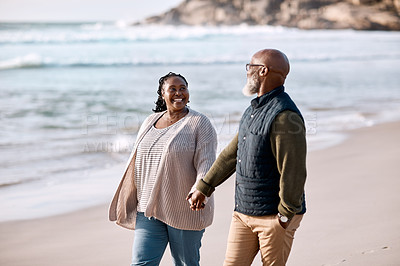 Buy stock photo Shot of a happy mature couple going for a romantic walk along the beach