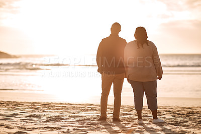 Buy stock photo Rearview shot of a happy mature couple watching the sunset at the beach