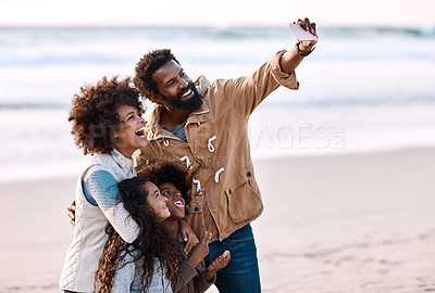 Buy stock photo Shot of a happy young family taking a selfie with a smartphone at the beach
