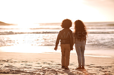 Buy stock photo Rearview shot of an adorable little boy and girl watching the sunset at the beach