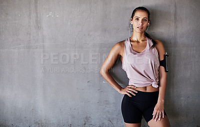 Buy stock photo Cropped portrait of an attractive young female athlete standing with her hand on her hip while working out in the city