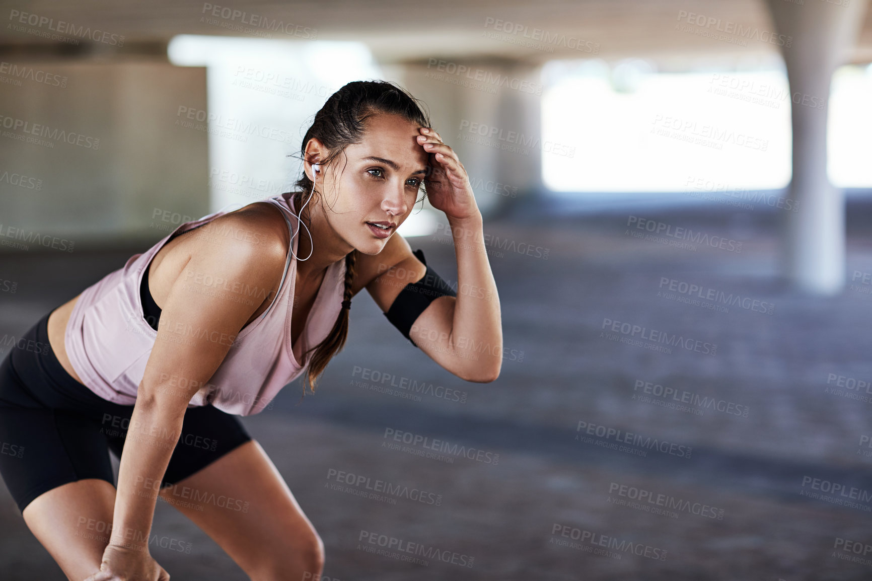 Buy stock photo Runner, fitness break and woman in city with exercise, tired or earphones for intense cardio routine. Sweat, fatigue and person with music for recovery, breathing or exhausted for endurance challenge
