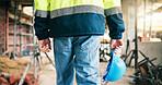 Man, hands and helmet at construction site for safety policy, renovation project or injury prevention. Person, PPE or hard hat in building for protection, infrastructure or civil engineering protocol