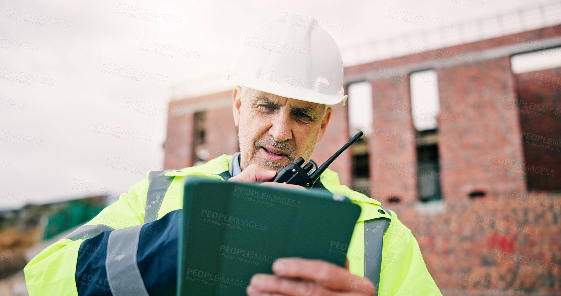 Buy stock photo Radio, man and civil engineer on site with tablet for update on building, architecture or renovation. Tech, planning and mature construction worker with feedback on repairs or property development.