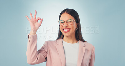 Buy stock photo Perfect, portrait and happy woman in studio for business success on a blue background. Female person, positive employee or smile with glasses, emoji or OK sign for perfection, accuracy or review