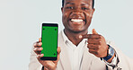Pointing, green screen and black man with phone in studio for advertising finance loyalty app. Happy, portrait and financial advisor with showing cellphone for internet banking on white background.