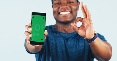 Buy stock photo Black man, phone and green screen in studio with approval for app, fitness or social media. Mockup space, okay gesture and happy person with tech for promotion or exercise program on white background