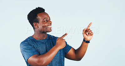 Buy stock photo Black man, smile and pointing in studio with space for presentation, product placement or offer. Happy person, mockup or promotion gesture with news for discount, sale or excited on white background