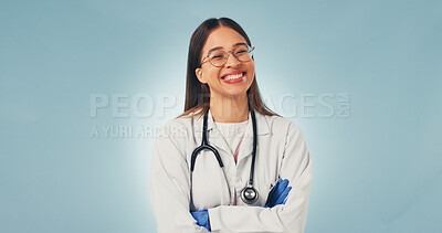 Buy stock photo Healthcare, doctor and happy woman in studio with confidence, portrait and space on blue background. Smile, arms crossed and medical worker with career integrity, about us and pride for wellness
