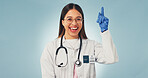 Doctor, portrait and happy woman in studio, promotion and advice for healthcare service or pointing. Blue background, medical expert and person with smile, presentation and laugh with health options
