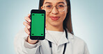 Green screen, doctor and hand with phone, medical advertising and telehealth on blue background. Woman, mobile and healthcare worker with display to show mockup, marketing space and studio portrait