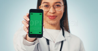 Buy stock photo Green screen, doctor and hand with phone, medical advertising and telehealth on blue background. Woman, mobile and healthcare worker with display to show mockup, marketing space and studio portrait