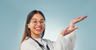 Buy stock photo Doctor, portrait and happy woman in studio, advice and presentation for healthcare service or point. Blue background, medical expert and person with smile, space and promotion with health options