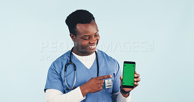Buy stock photo Nurse, point or phone in studio with green screen, man and advertising promotion for telehealth app. Happy, black person or healthcare worker with tech, medical space or marketing on blue background.