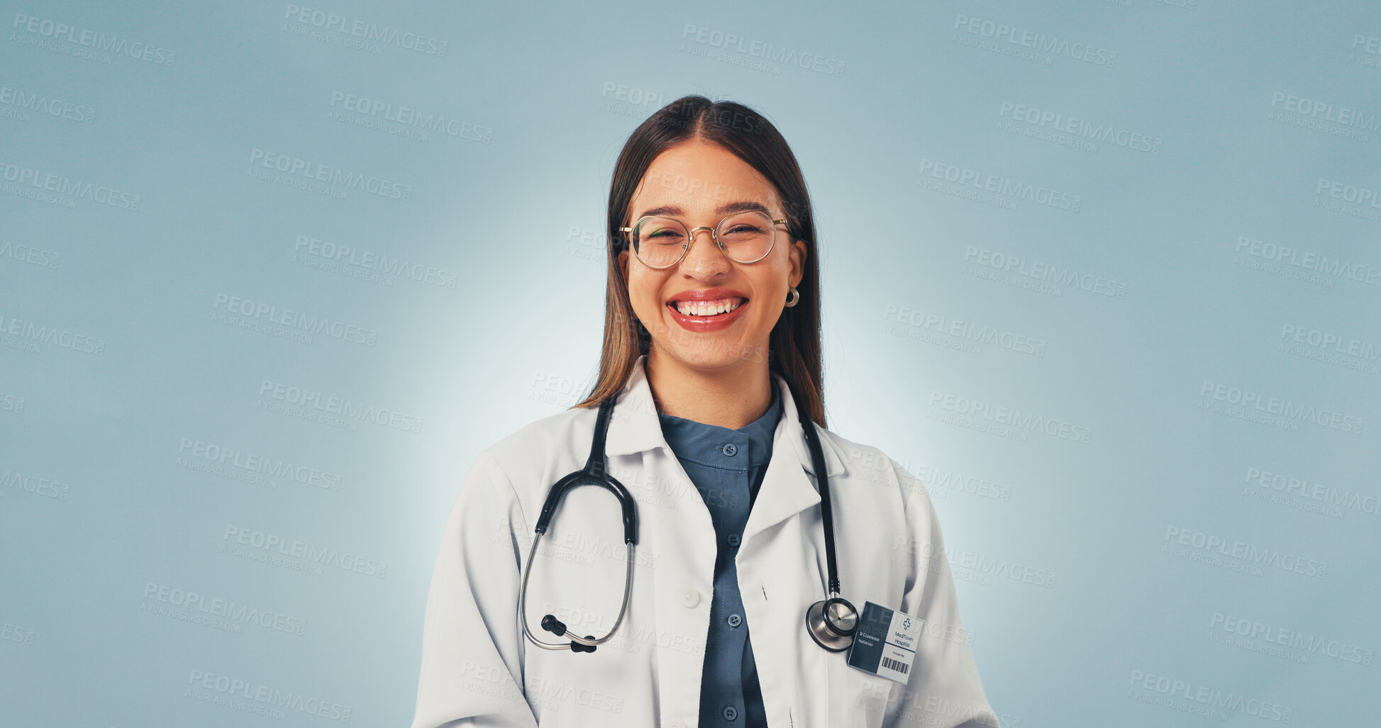 Buy stock photo Portrait, doctor and woman in studio with smile, medical career and cardiology expertise with glasses. Happy, person and cardiologist with healthcare job, about us or mockup space on blue background.