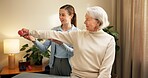 Physiotherapist, senior and woman with dumbbell in private practice for weightlifting or session. Female person, coach or therapist with elderly client or weight for muscle recovery or rehabilitation
