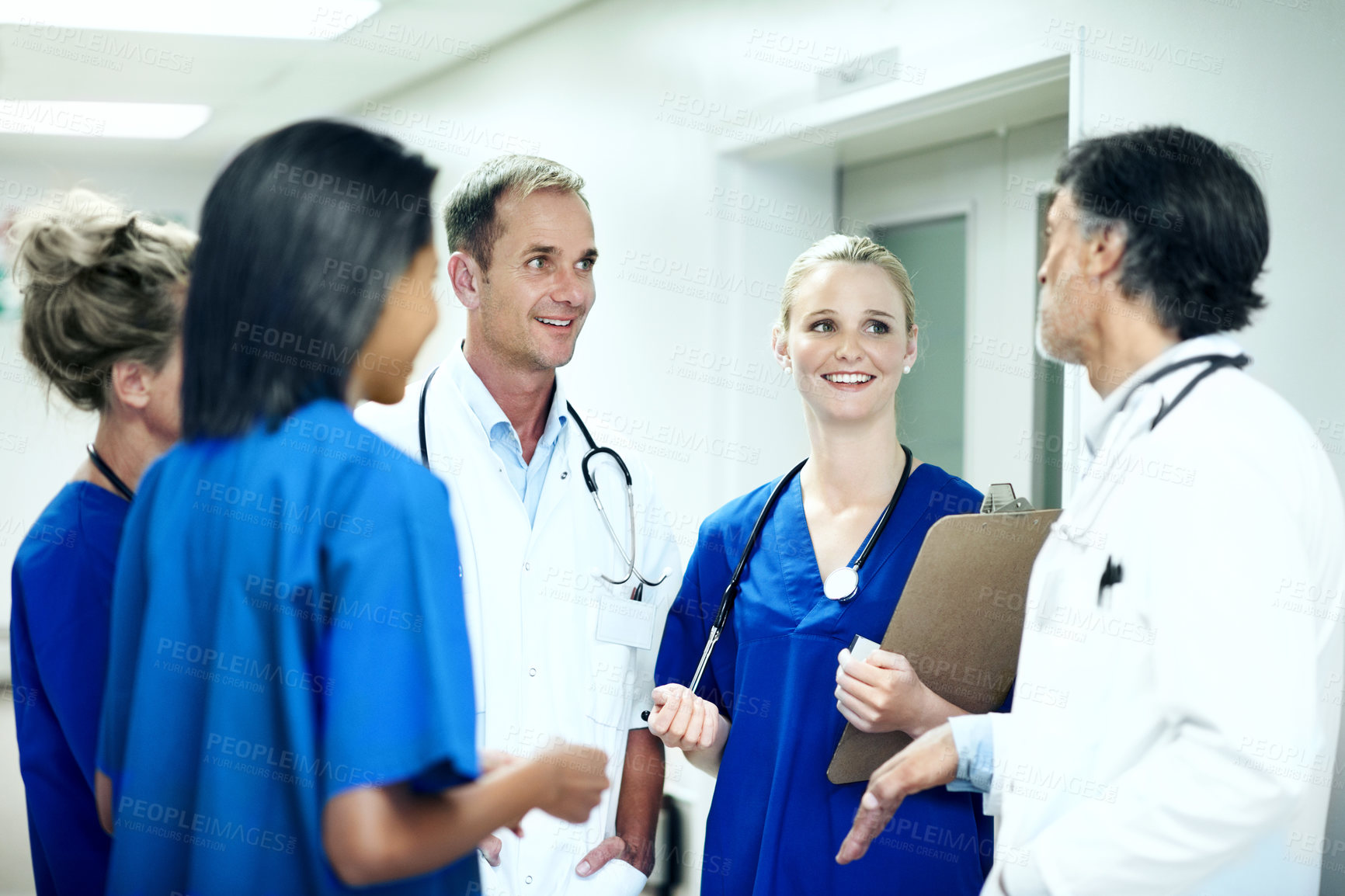 Buy stock photo Team, talking and consulting with doctors in hospital for healthcare, solidarity and meeting. Medical, community and discussion with group of people in hallway of clinic for support and collaboration