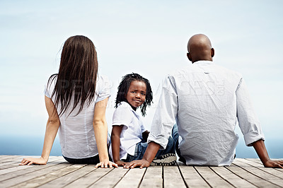 Buy stock photo Rearview shot of a young family sitting outside