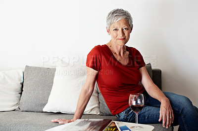 Buy stock photo Portrait of a smiling mature woman drinking wine in her living room