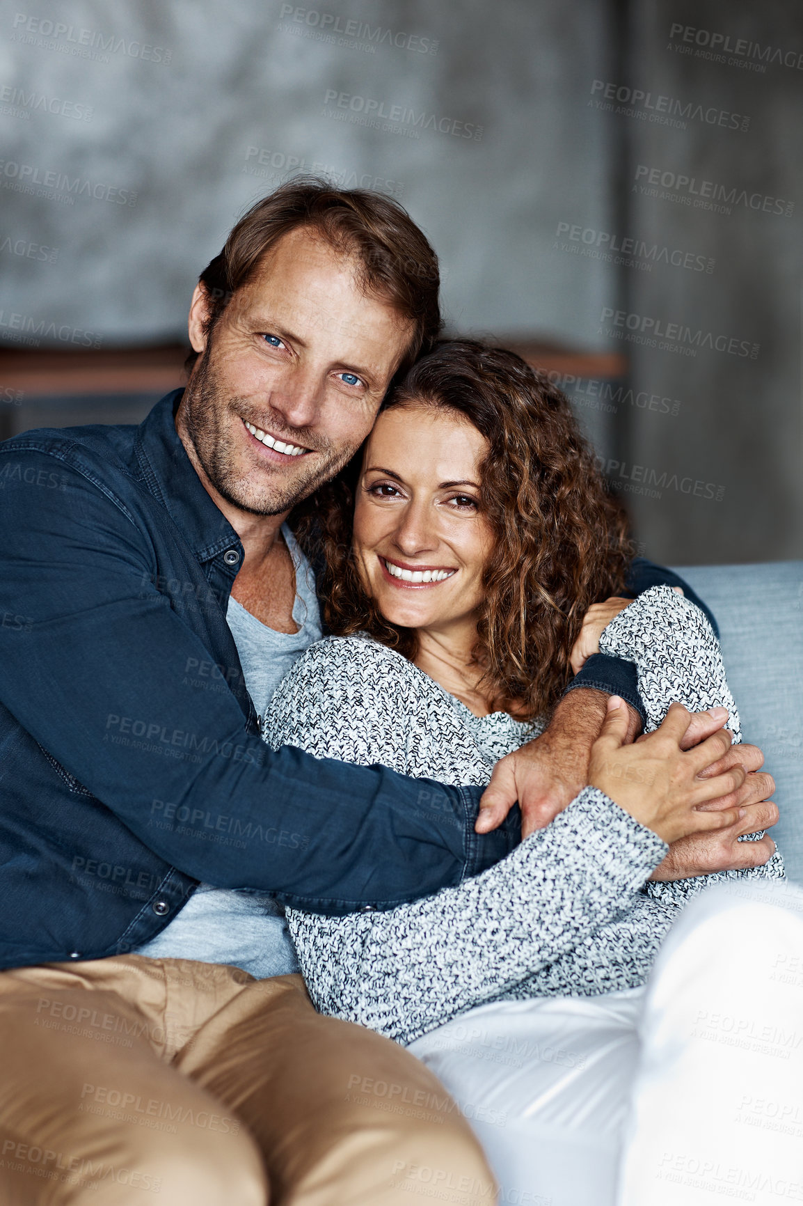 Buy stock photo Portrait of a smiling mature couple sitting on a sofa in their living room