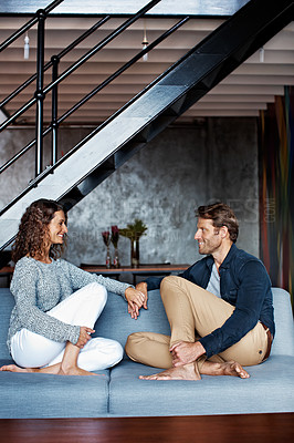 Buy stock photo Shot of an affectionate mature couple holding hands while sitting on a sofa in their living room