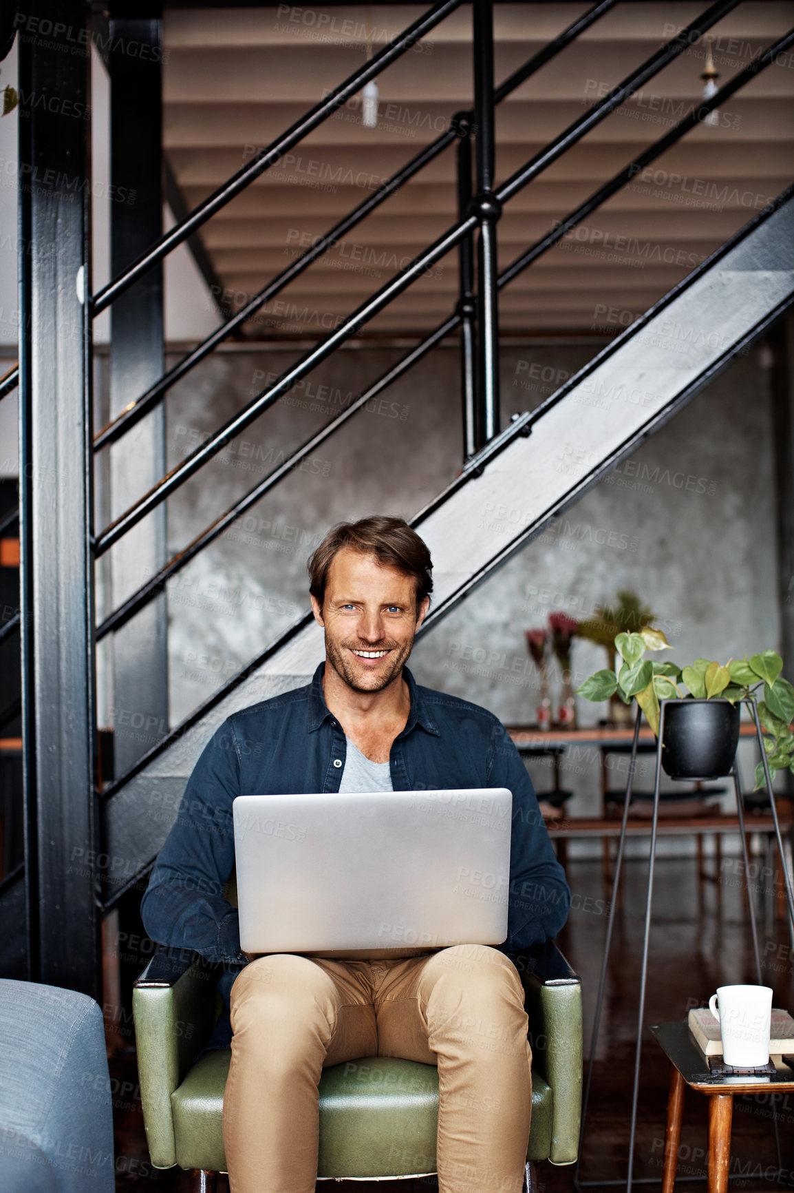 Buy stock photo Portrait of a mature man sitting on a chair in his living room using a laptop