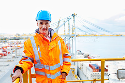 Buy stock photo Portrait of a man in workwear standing on an overhead walkway at a large commercial dock