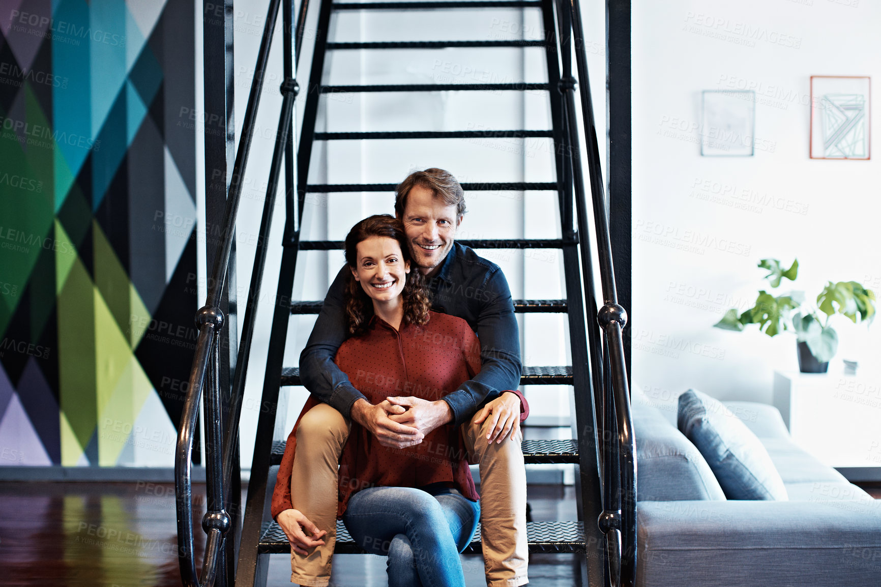Buy stock photo Portrait of a smiling mature couple sitting on stairs in their loft