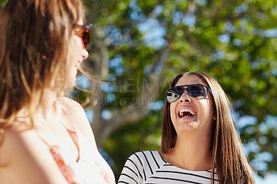 Buy stock photo Shot of two young friends standing outside laughing