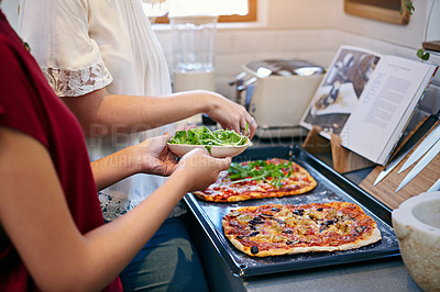 Buy stock photo Cropped shot of two young friends making pizza together