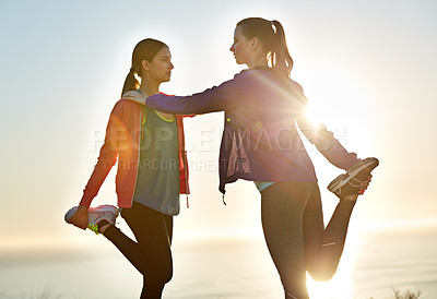 Buy stock photo Shot of two young friends stretching before a trail run