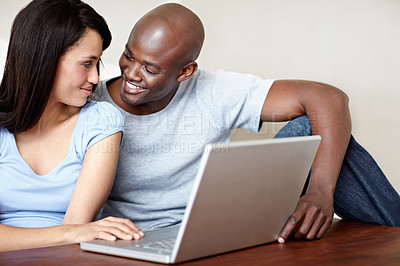 Buy stock photo Shot of a young couple using a laptop together at home