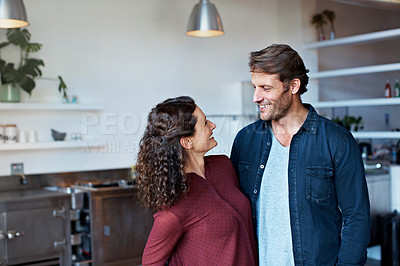 Buy stock photo Shot of an affectionate couple standing arm in arm in their living room
