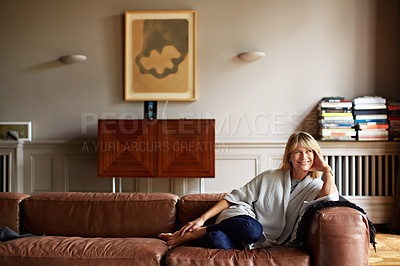 Buy stock photo Portrait of a mature woman relaxing on her living room sofa