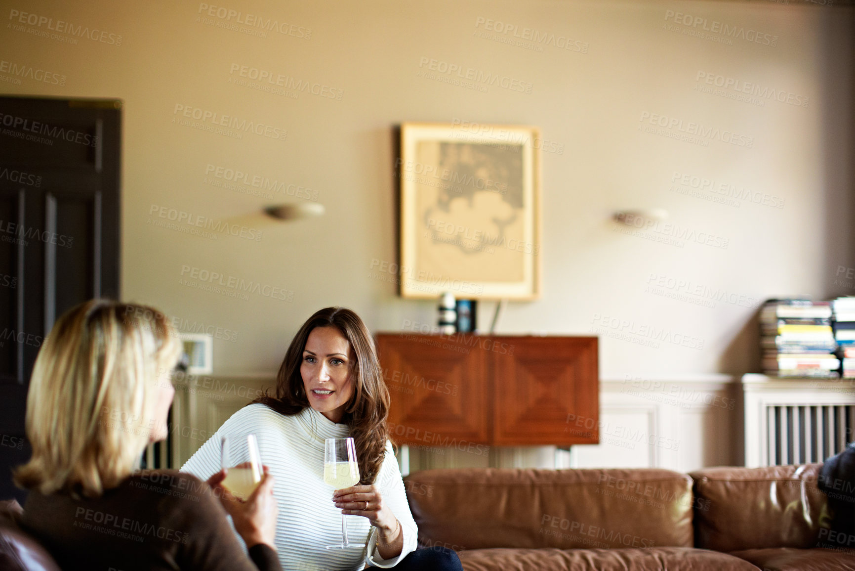 Buy stock photo Talking, relax and wine with friends on sofa in home for bonding, support and care together. Discussion, chat and connection with women in living room in house for alcohol drink, advice and gossip