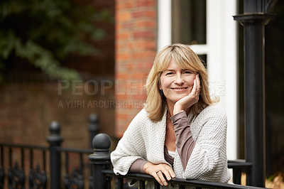 Buy stock photo Portrait of a mature woman leaning against the railing of her front porch