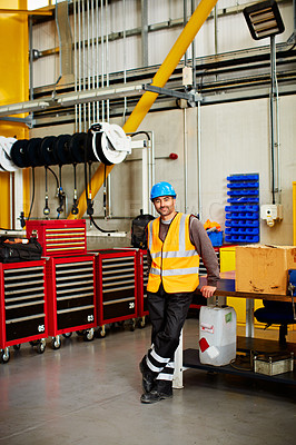 Buy stock photo Portrait of a man in workwear standing by toolboxes in a large industrial building