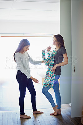 Buy stock photo Shot of a young woman helping her friend choose something to wear