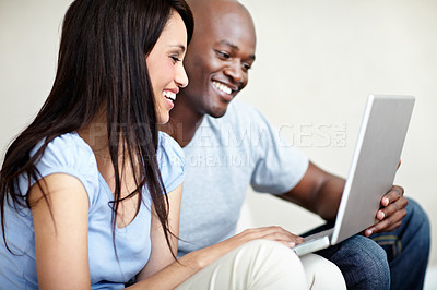 Buy stock photo Shot of a young couple using a laptop together at home