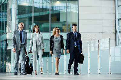 Buy stock photo Shot of businesspeople walking through the lobby of an office building