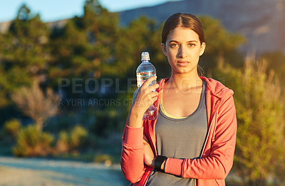Buy stock photo Portrait of a young woman taking a water break while out for a cross country run