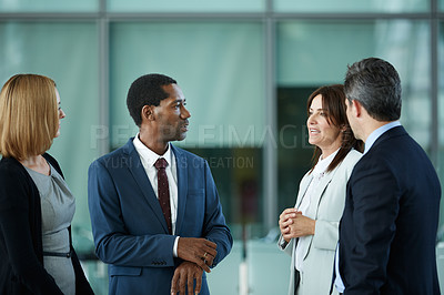 Buy stock photo Shot of a diverse group of businesspeople talking together in the lobby of an office building