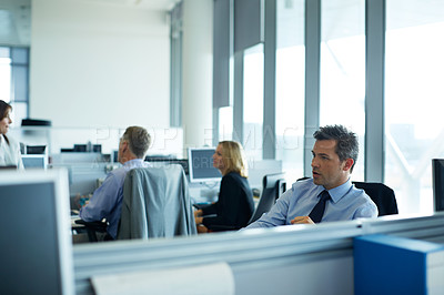 Buy stock photo Shot of businesspeople working at their desks in an office