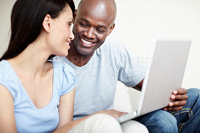 Buy stock photo Shot of a young couple using a laptop together at home