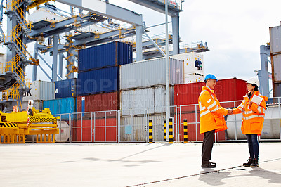 Buy stock photo Shot  of two workers shaking hands on a commercial dock